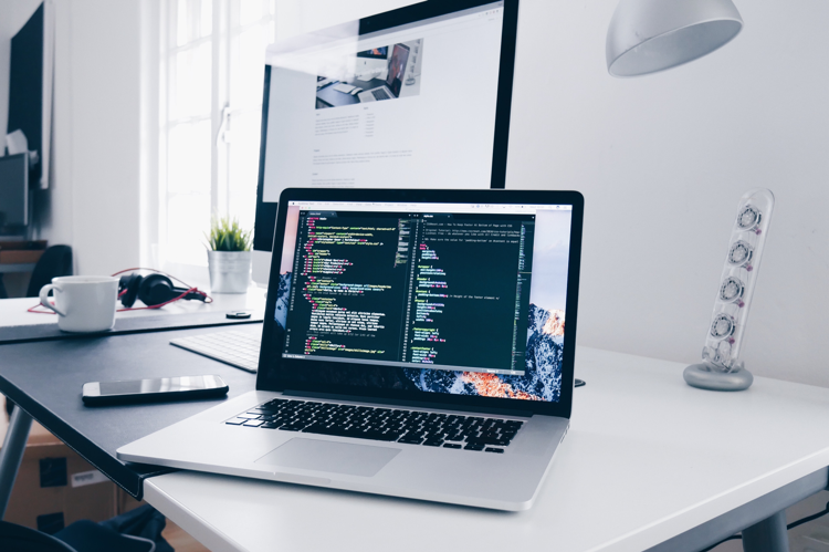 white desk with a laptop and monitor